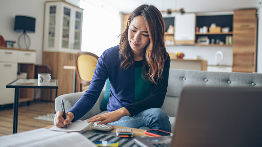A woman recording figures in an accounting ledger.