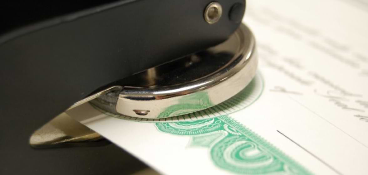 A metal seal stamping a certificate.