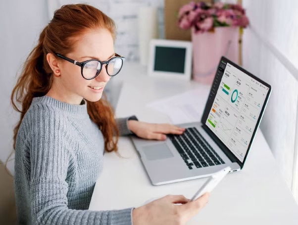 Woman using QuickBooks accounting software on laptop.
