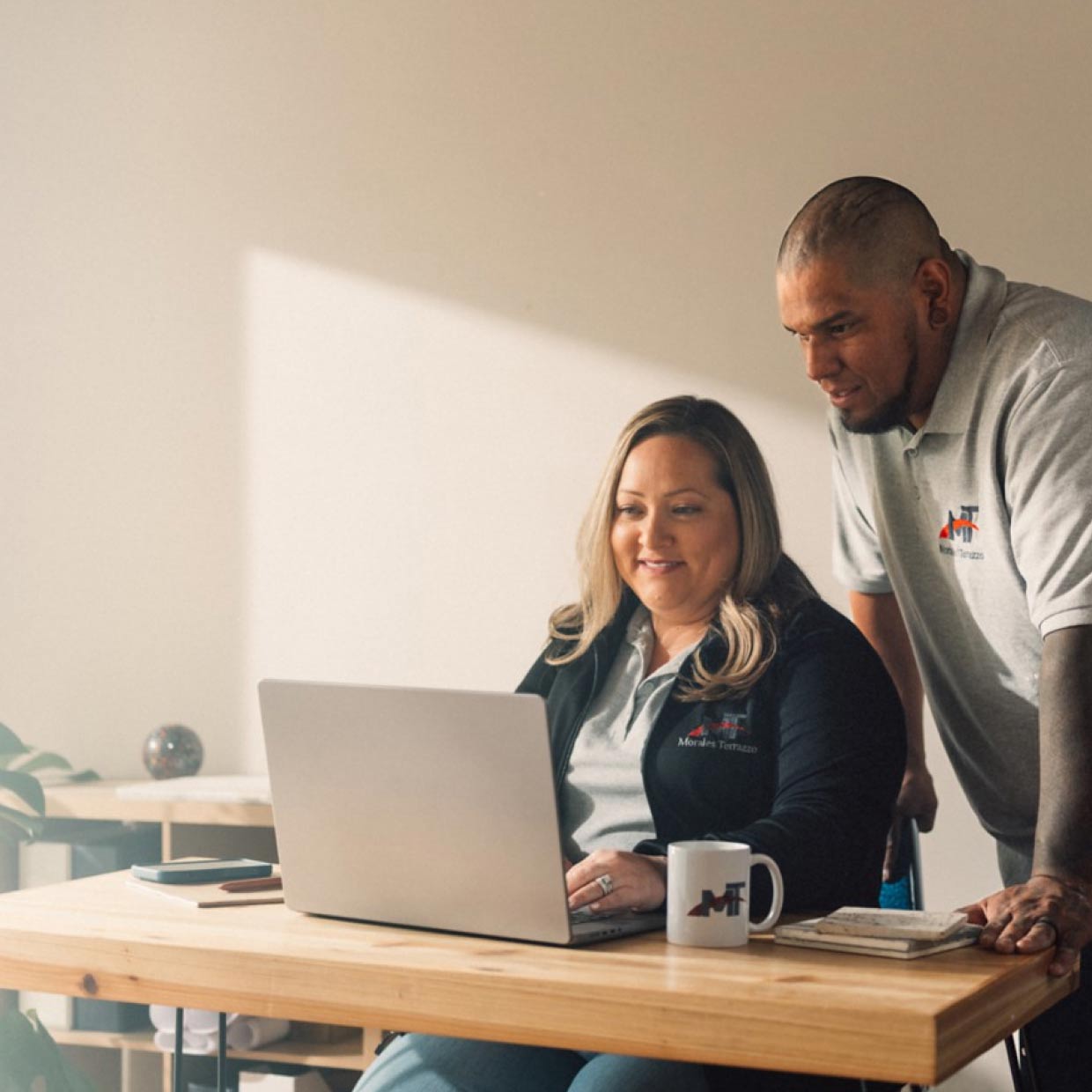 Business owners review their business performance on a laptop.