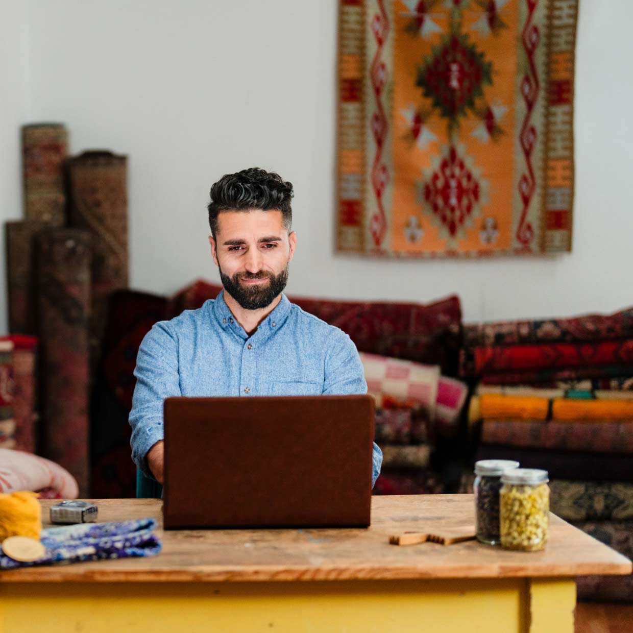 The owner of a rug company sits at his computer