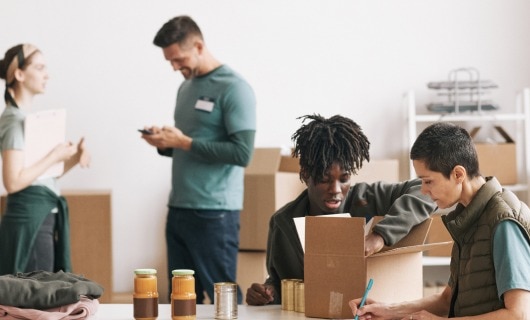 Four people working for a non-profit unpacking donation boxes.