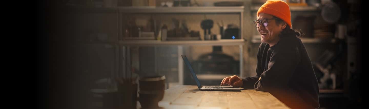 A person sitting at a table with a laptop.