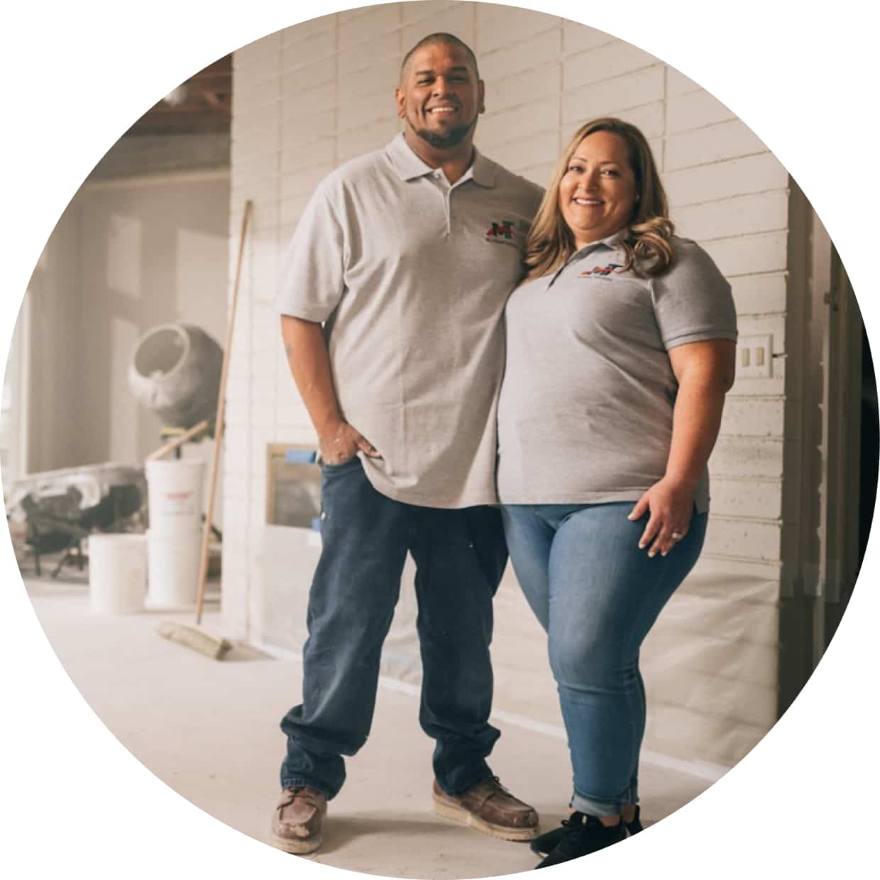 Two small business owners pose in their workspace.