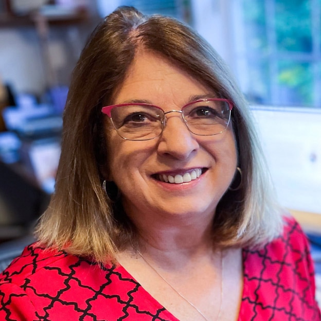 A QuickBooks Live customer named Karen Krueger, owner of Krueger Event Management, is sitting and smiling.