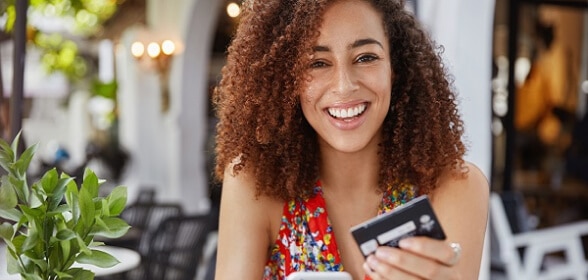 Diner holding a credit card, smiling.