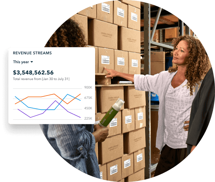 Two women having a conversation next to a stack of boxes. A graphic overlay shows a graph and revenue streams for the year.