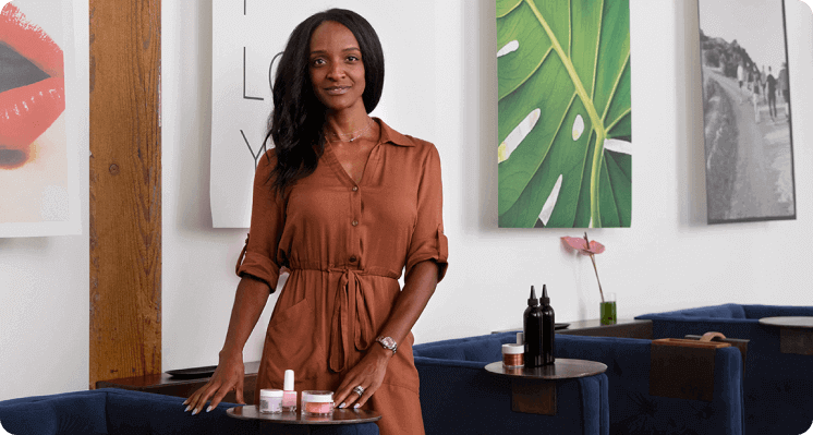 A business owner standing in their salon smiling at the camera.